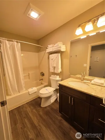 a bathroom with a granite countertop toilet sink and mirror