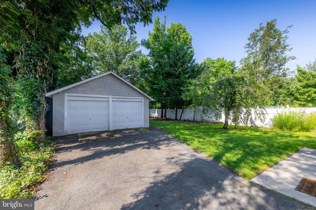 a wooden house with a small yard and large trees