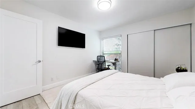 a bedroom with a bed and a flat screen tv