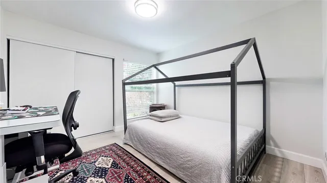 a bedroom with a bed and a large window with the backyard view