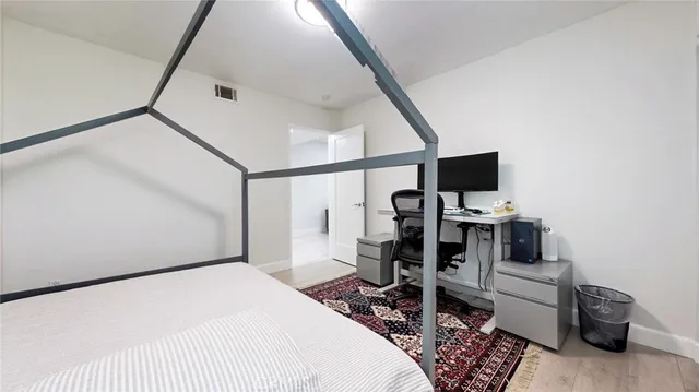 a bedroom with a bed and wooden floor