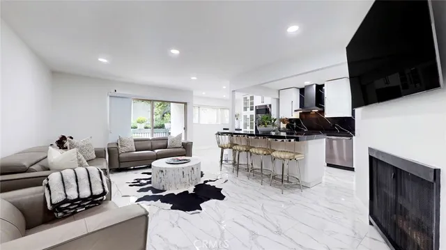 a kitchen with stainless steel appliances kitchen island granite countertop a stove a sink and a white cabinets