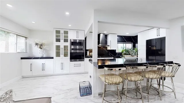 a kitchen with stainless steel appliances a refrigerator sink and white cabinets