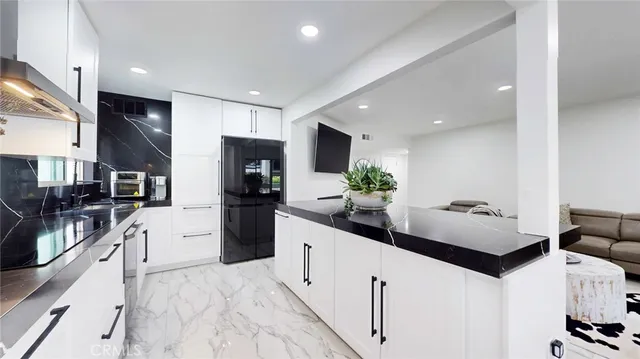 a large white kitchen with stainless steel appliances