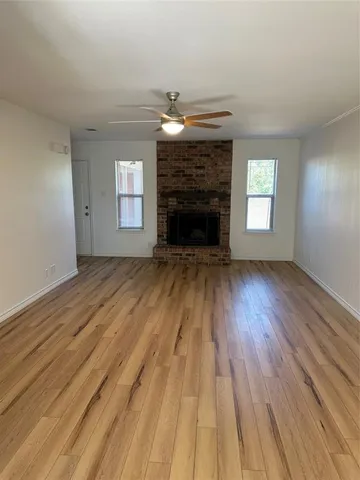 wooden floor fireplace and windows in an empty room