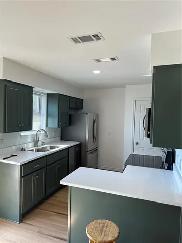 a kitchen with kitchen island stainless steel appliances a sink and stove