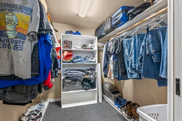 a view of walk in closet with clothes and shoes