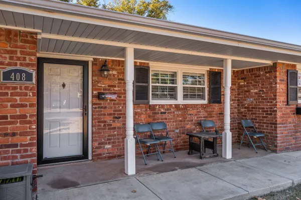 front view of a brick building with a bench in front of door