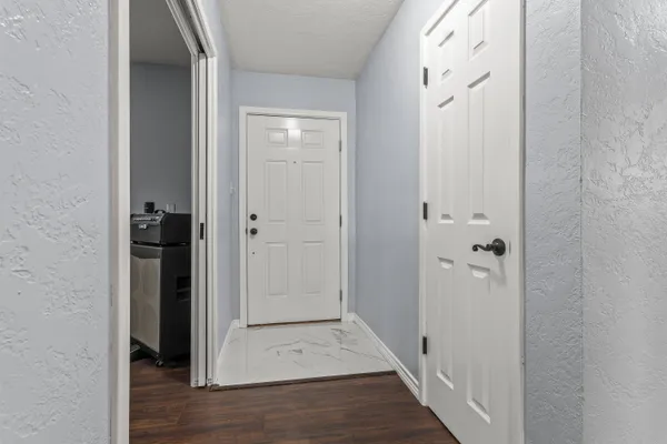 wooden view of a hallway with wooden floor and closet area