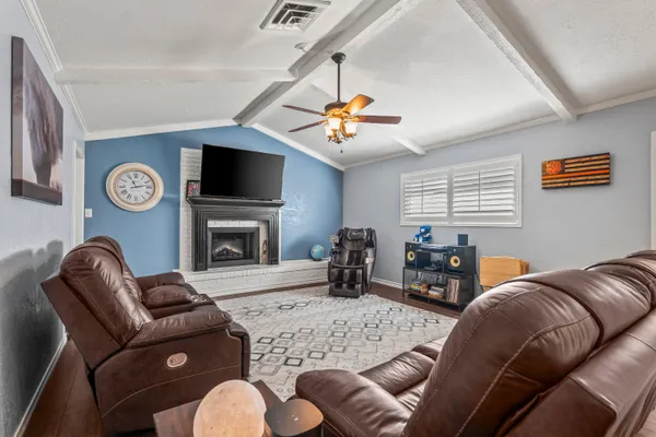 a living room with furniture a flat screen tv and a fireplace