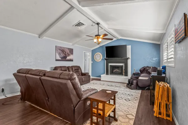 a living room with furniture a flat screen tv and a fireplace