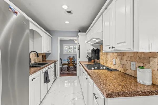 a kitchen with stainless steel appliances granite countertop a sink stove and refrigerator