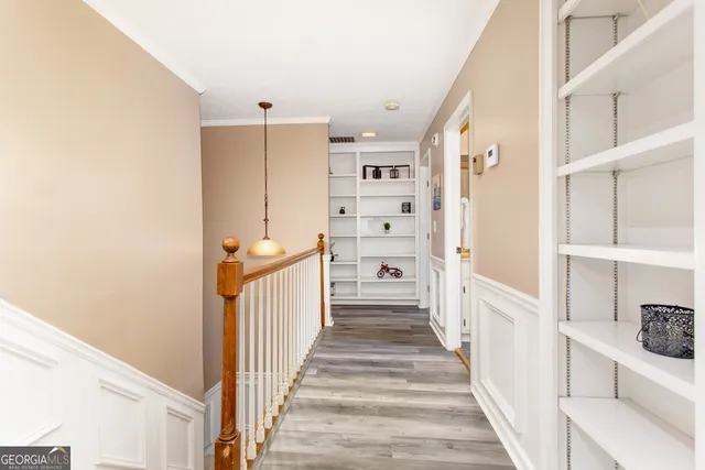 a view of a hallway with wooden floor and windows
