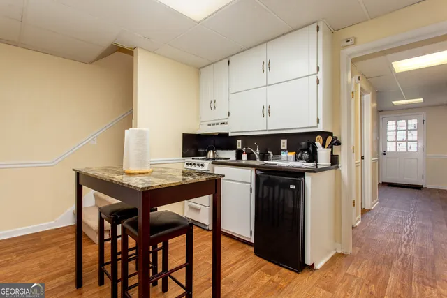 a kitchen with stainless steel appliances granite countertop a table chairs and a refrigerator