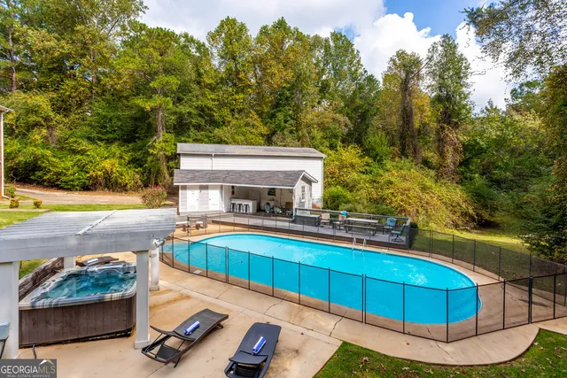 a view of a swimming pool with back yard of the house