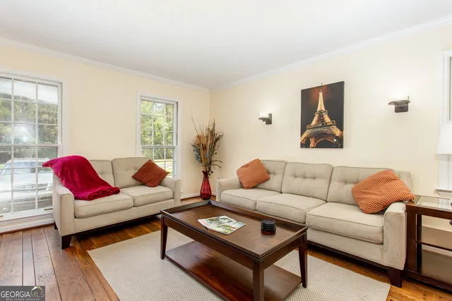 a living room with furniture a rug and a window
