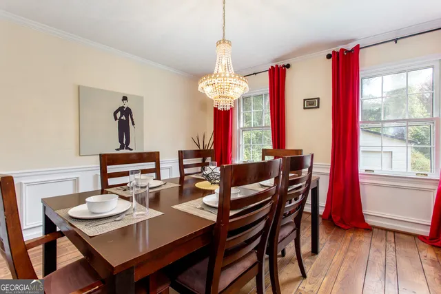 a dining room with furniture a chandelier and wooden floor