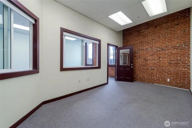 a view of an empty room with brick wall and closet