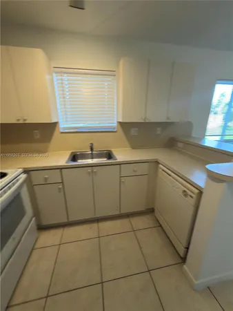 a kitchen with a sink a stove top oven and cabinets