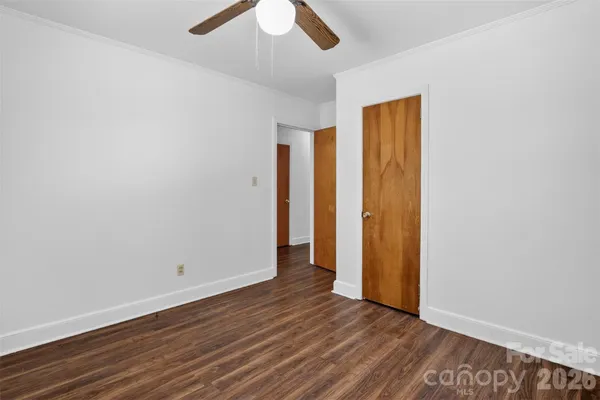 an empty room with wooden floor and closet