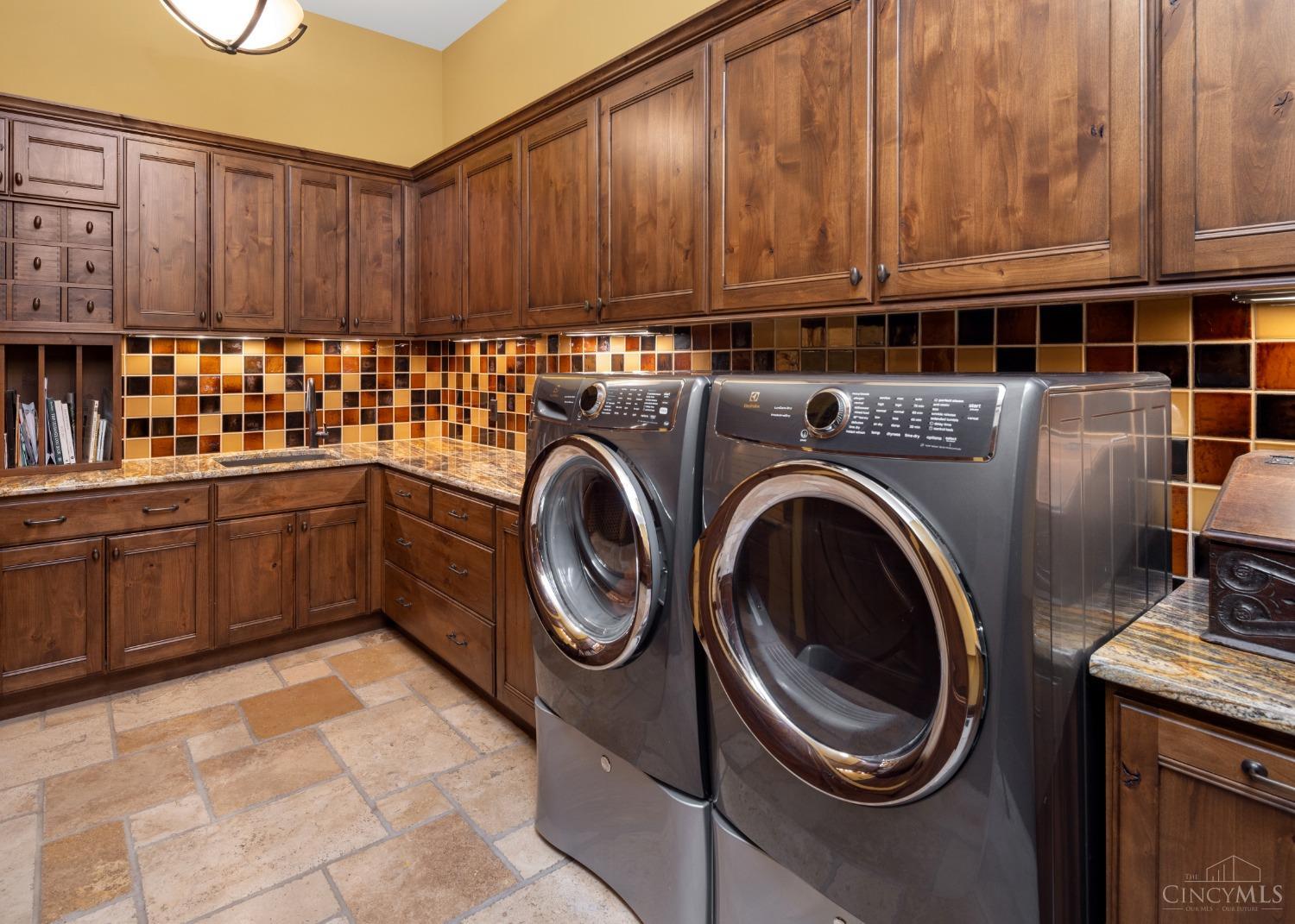 5900 Park Road Cincinnati, OH 45243 - Photo 21 of 50 First floor laundry (15’ X 9’) Located garage side and steps from first floor guest suite is this first floor laundry complete with washer and dryer, custom cabinetry, planning area/work station, and limestone flooring. Note: There is also a second laundry room (8’ X 7’) on the second floor.