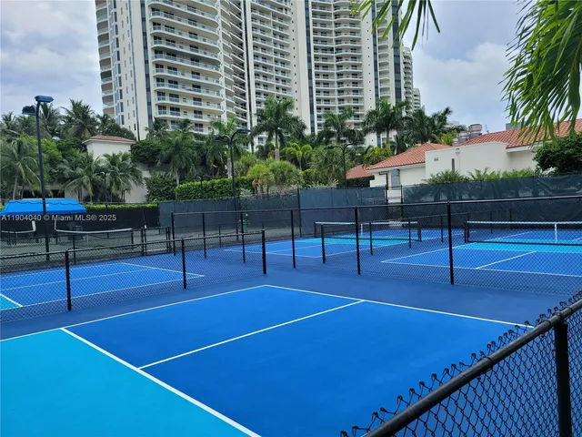a view of a tennis court with wooden fence