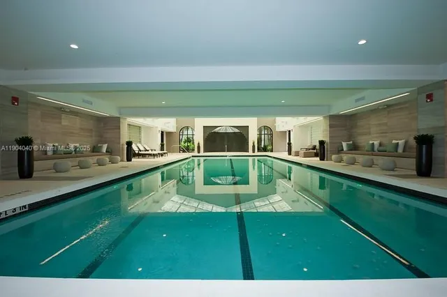 a living room with large window and furniture