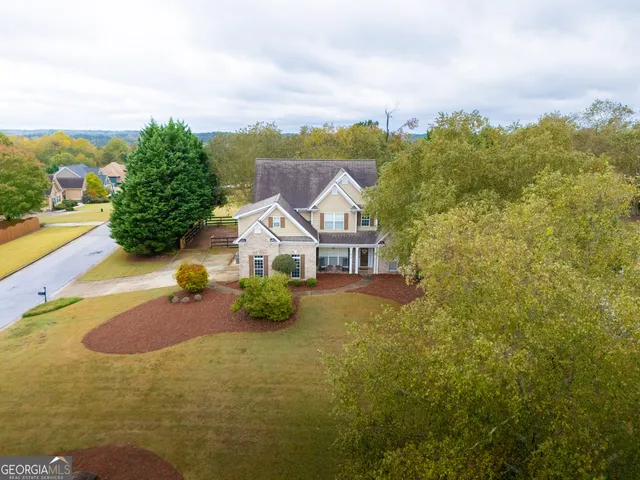 an aerial view of a house with swimming pool and mountains