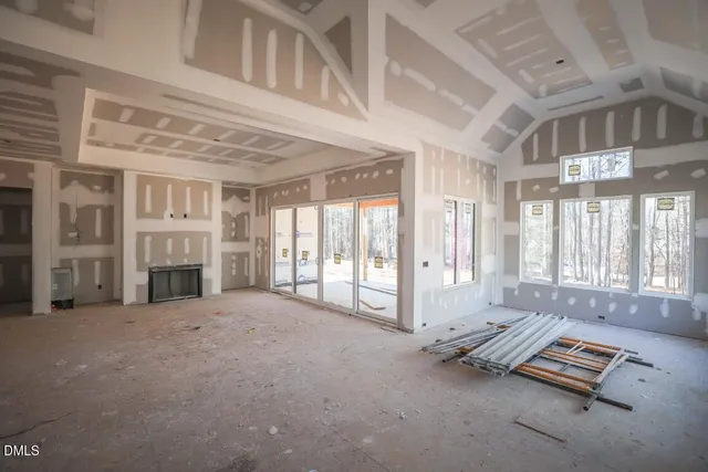 a view of an empty room with a fireplace and a window