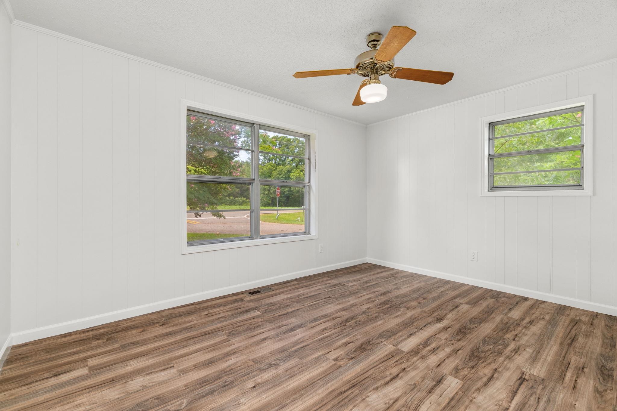 217 Red Bay Road Golden, MS 38847 - Photo 17 of 33 Room featuring wood-finish flooring, two windows, and a ceiling fan with integrated lighting