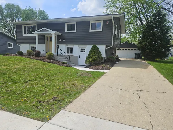 a front view of a house with a yard and trees
