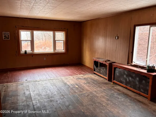 a view of an empty room with a fireplace and a window