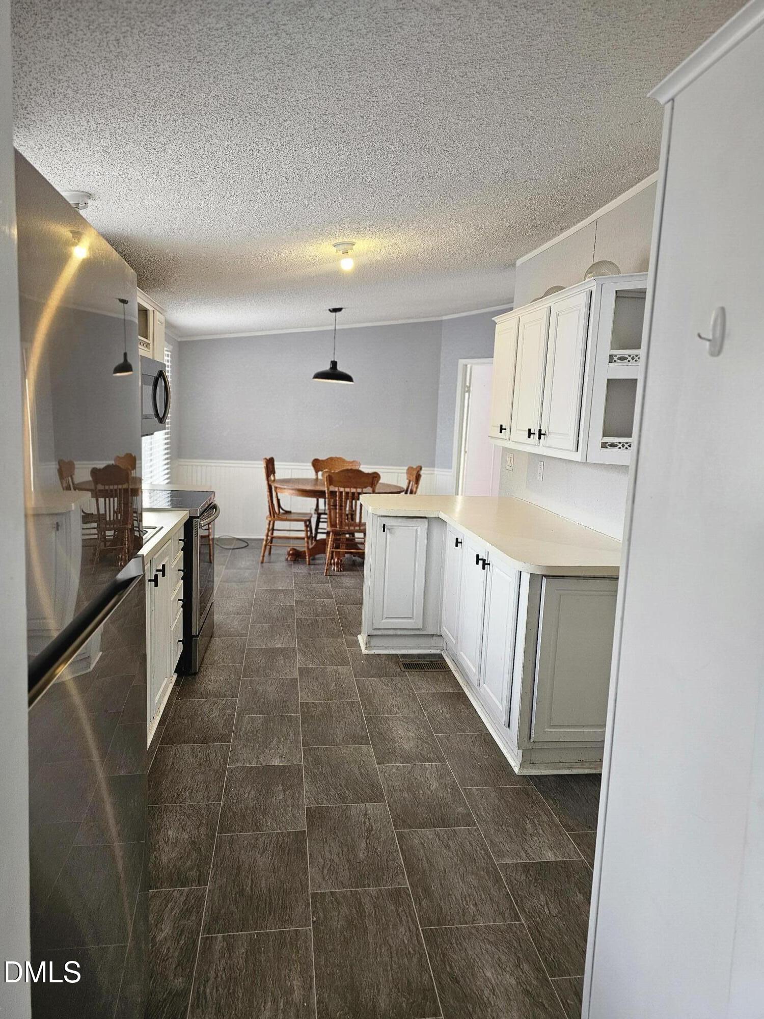 4762 Old Allensville Road Roxboro, NC 27574 - Photo 8 of 33 a large white kitchen with stainless steel appliances granite countertop a sink and dishwasher a oven with white cabinets
