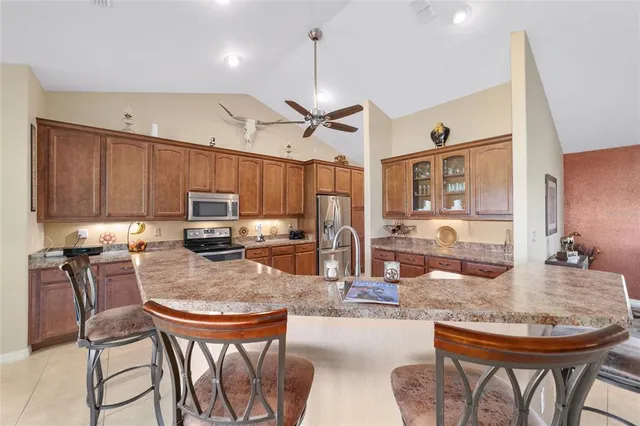 a kitchen with sink a refrigerator and chairs