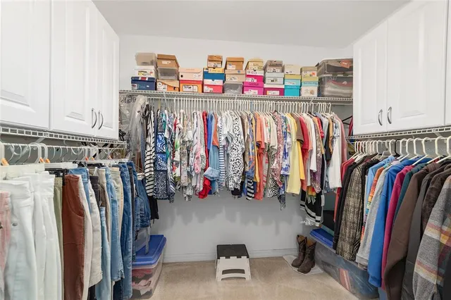 a view of walk in closet with clothes