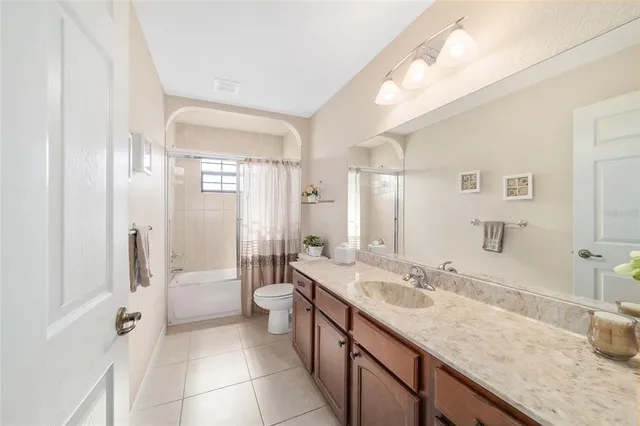 a bathroom with a sink double vanity granite tub shower and a mirror