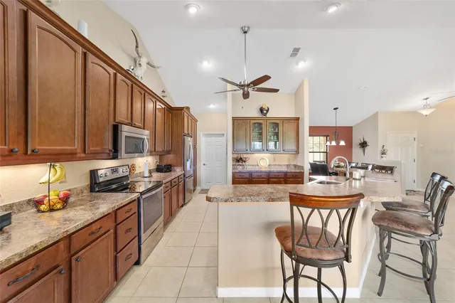 a kitchen with stainless steel appliances kitchen island granite countertop a sink and cabinets