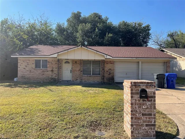 a front view of a house with a garden and yard