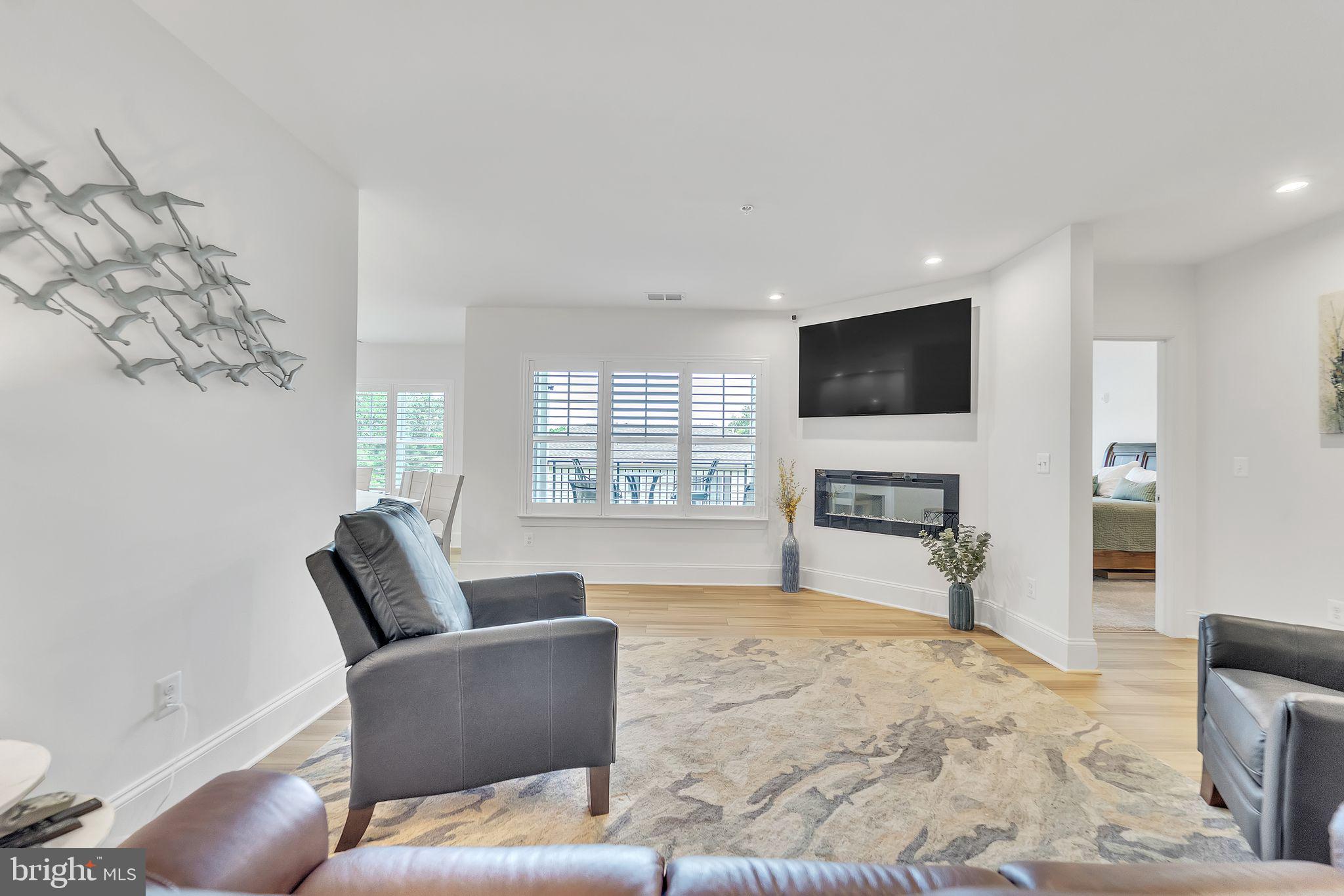 1414 Burke Road, Unit 201 Middle River, MD 21220 - Photo 11 of 35 a living room with furniture a flat screen tv and a large window