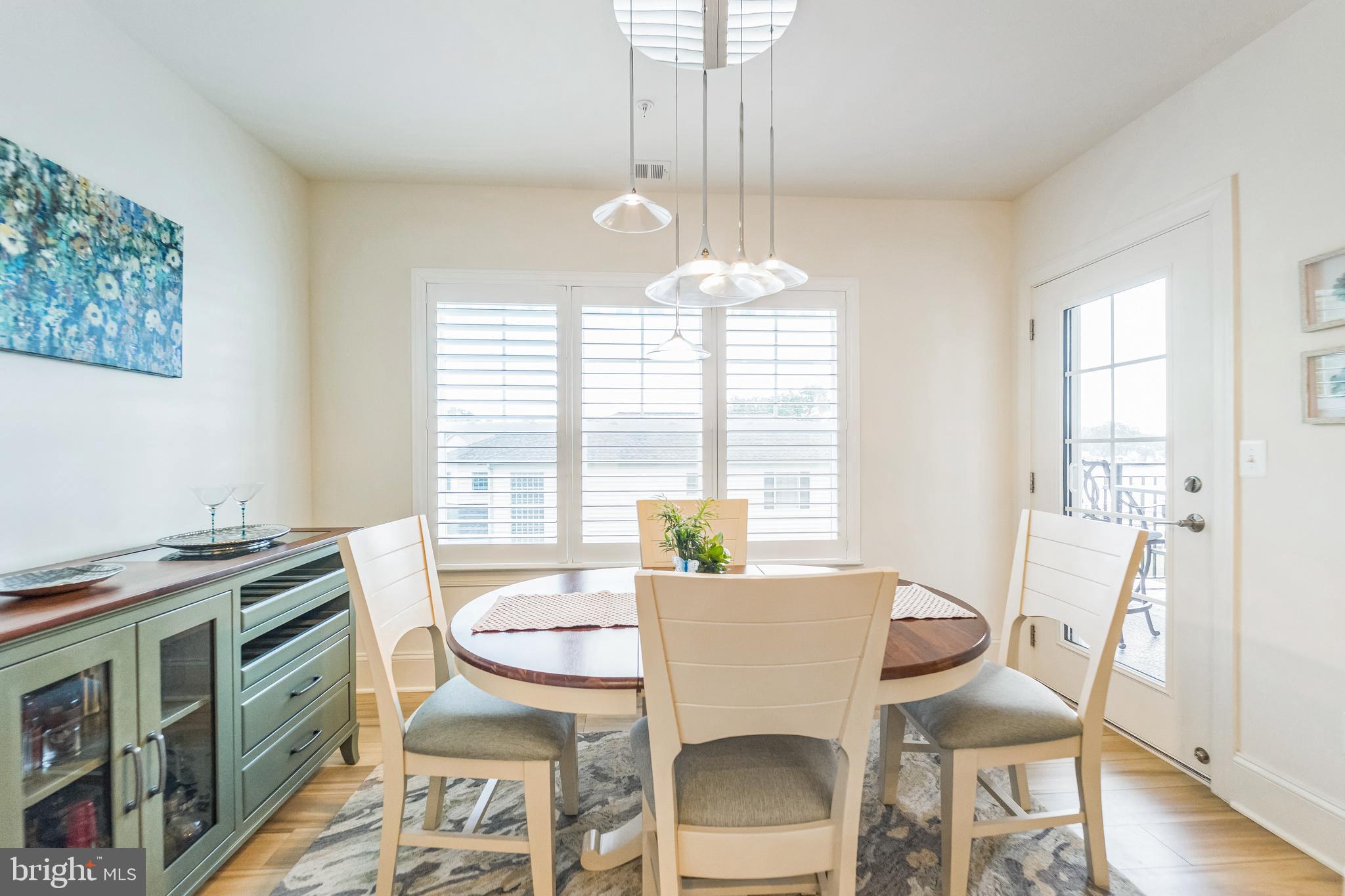 1414 Burke Road, Unit 201 Middle River, MD 21220 - Photo 18 of 35 a view of a dining room with furniture a chandelier and wooden floor