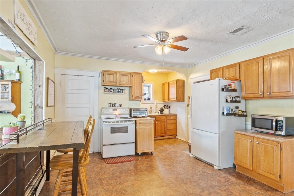 37 Draper Road Gardner, MA 01440 - Photo 12 of 33 a kitchen with a refrigerator a stove top oven a sink dishwasher and dining table with wooden floor