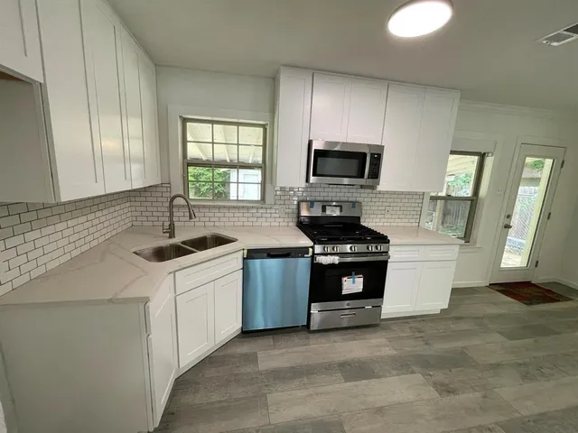 a kitchen with a sink a stove and microwave
