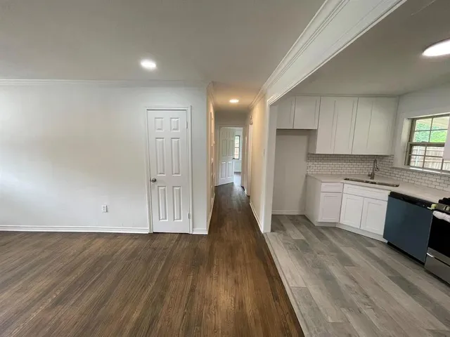 a view of a kitchen with wooden floor and a sink