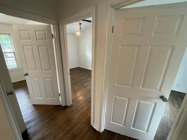 a view of a hallway with wooden floor
