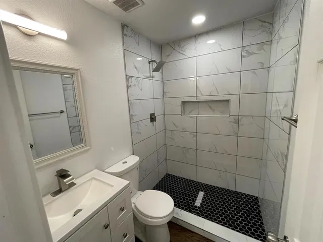 a bathroom with a sink toilet and shower