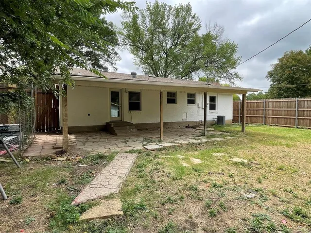a view of a house with backyard and trees