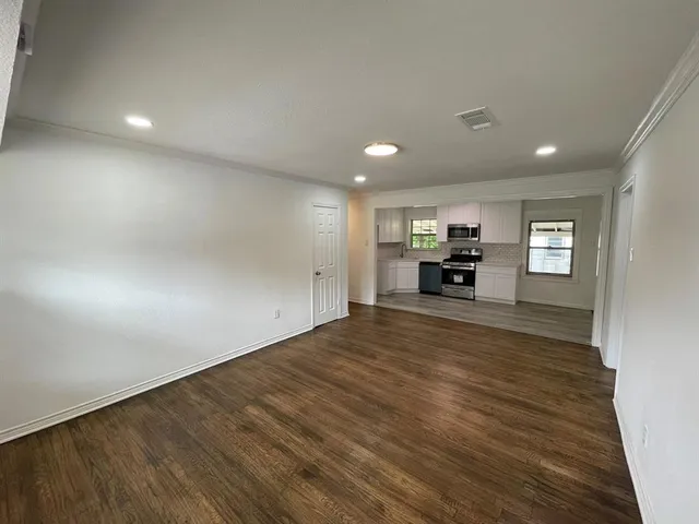 a view of empty room with wooden floor