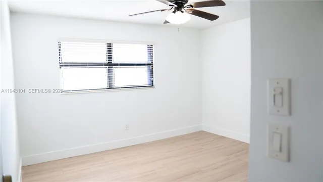 an empty room with wooden floor chandelier fan and closet