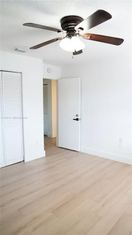 an empty room with a window and a ceiling fan