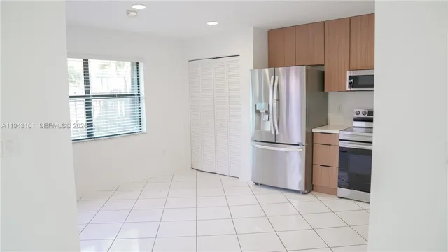 a kitchen with a refrigerator a stove top oven and cabinets
